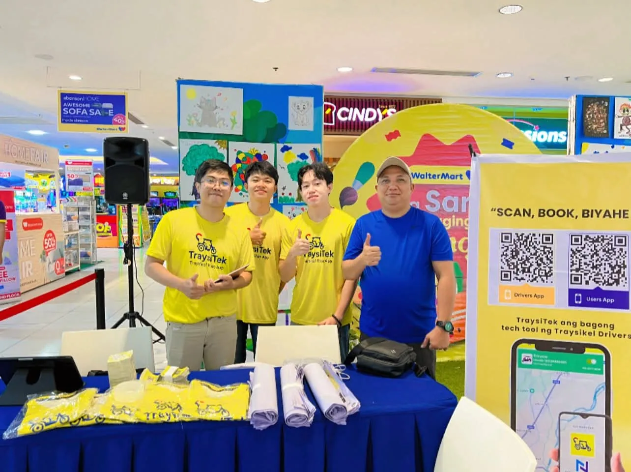 The TraysiTek team at their launch booth in WalterMart San Jose with QR codes for the passenger and driver apps